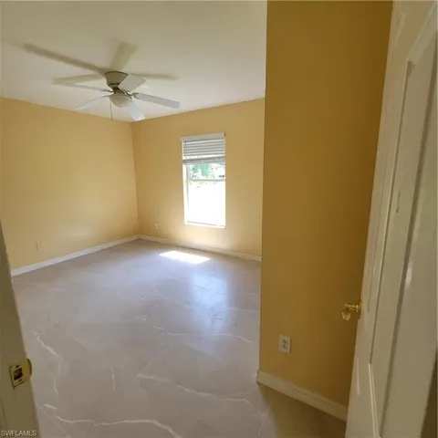Unfurnished room featuring baseboards and ceiling fan