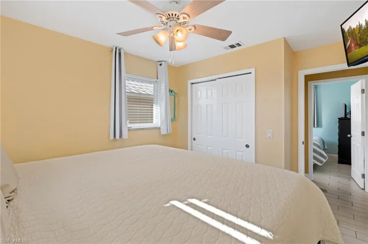 Bedroom featuring wood-type flooring, a closet, and ceiling fan