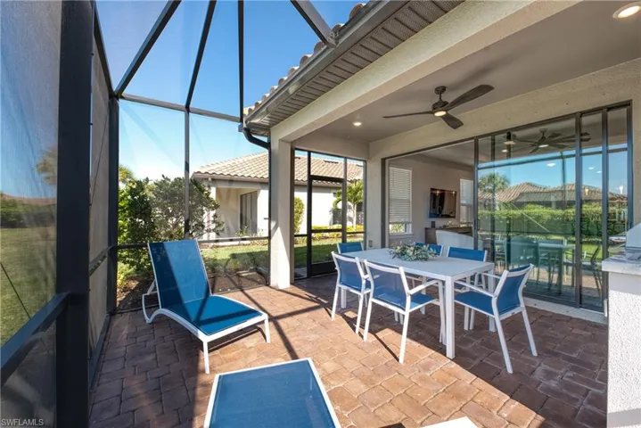 Screened lanai featuring brick paver flooring, a ceiling fan with integrated lighting, and direct access to the interior via large sliding glass doors