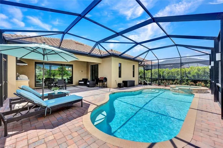 View of pool featuring a patio, a lanai, an in ground hot tub, and an outdoor living space