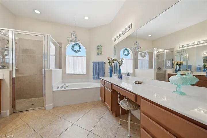 Primary bathroom designed for comfort with dual sinks and separate tub and shower