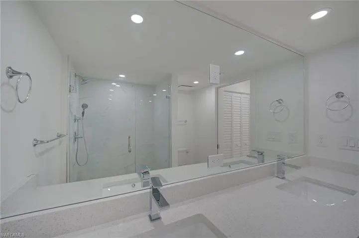 Dual vanity with integrated sinks and chrome faucets, set on a speckled light-toned countertop