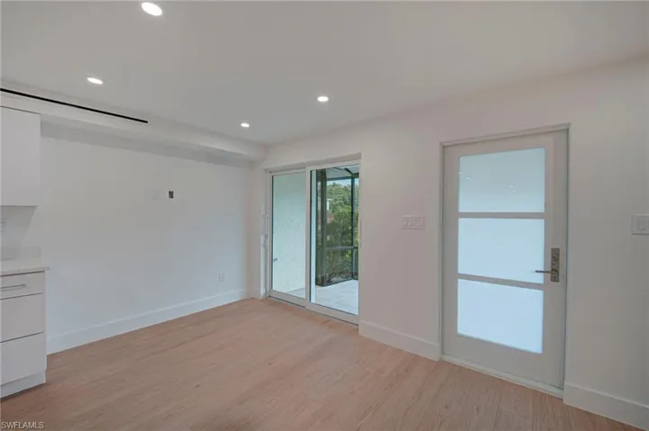 Light wood-finish flooring with white baseboards throughout