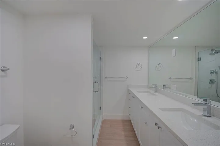 Dual sink vanity with white cabinetry and light-colored countertops