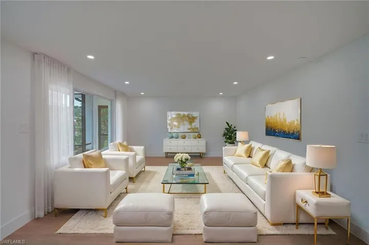 Spacious living room featuring wood-finish flooring and recessed lighting