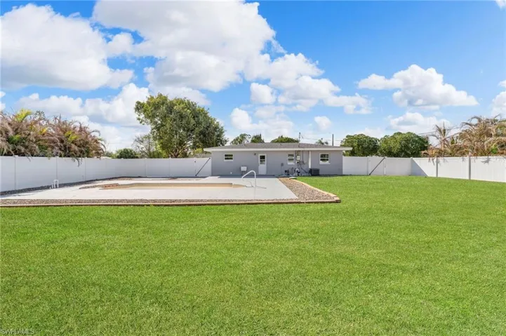 Rear view of property with a fenced backyard and a patio area