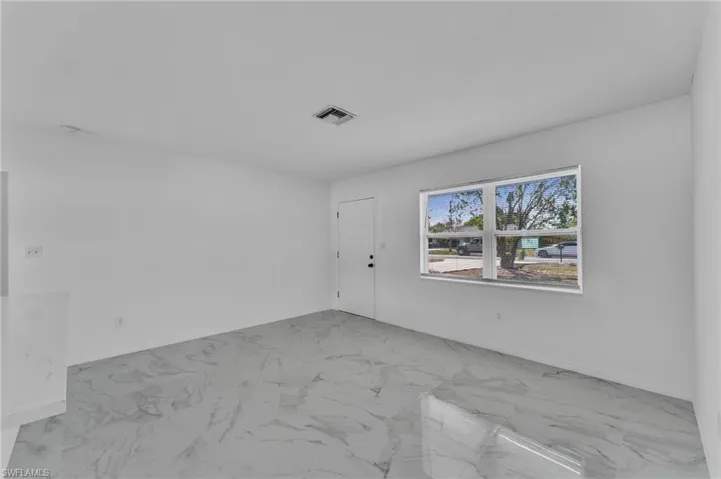 Spare room with baseboards and light marble finish floors