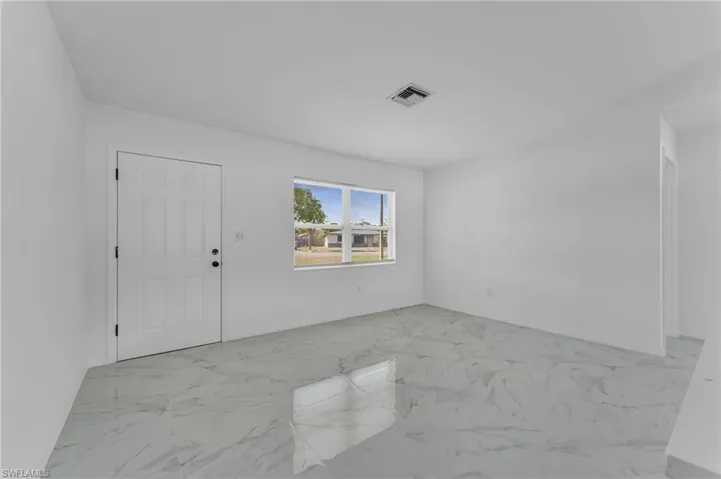 Foyer entrance featuring light marble finish floors