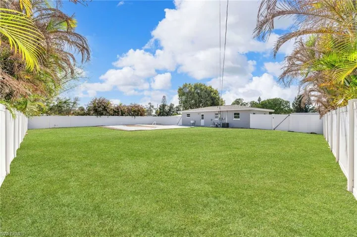 Rear view of house featuring a fenced backyard and a gate