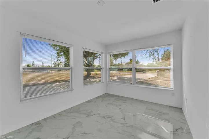 Unfurnished sunroom featuring marble finish floors and plenty of natural light