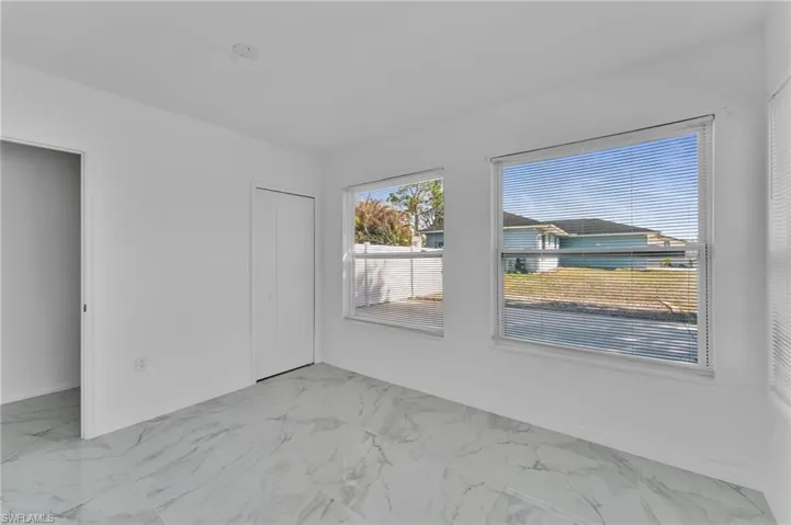 Unfurnished bedroom featuring a closet and light marble finish flooring