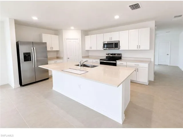 Modern kitchen with stainless steel appliances and large center island.
