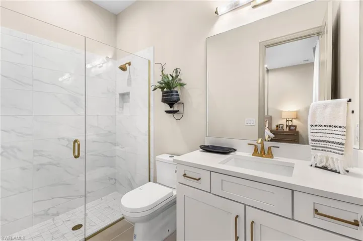 Full bath with a stall shower, vanity, and ensuite bath