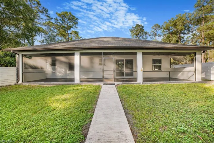 Back of house with a sunroom, a yard, a patio, and ceiling fan