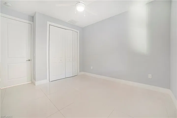 Unfurnished bedroom featuring light tile patterned flooring, a closet, and ceiling fan