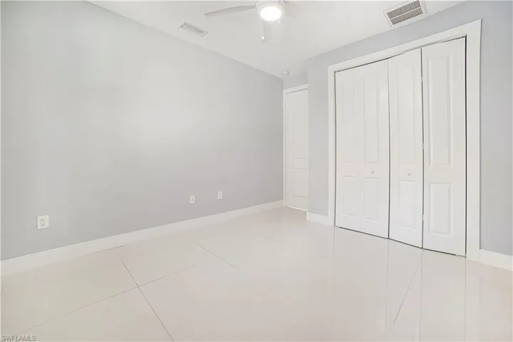 Unfurnished bedroom with a closet, light tile patterned floors, and ceiling fan