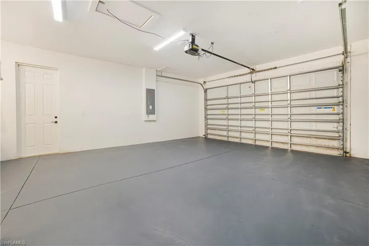 Garage featuring a garage door opener and electric panel