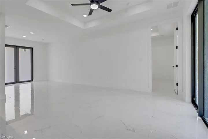Spare room with ceiling fan, french doors, and a tray ceiling