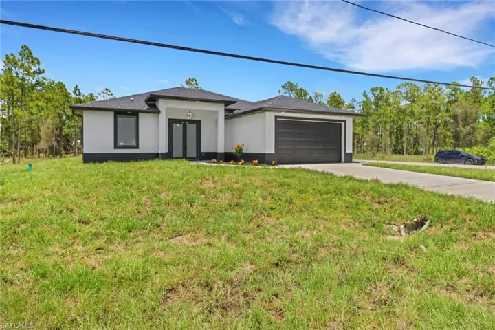 View of front of home featuring a garage and a front yard