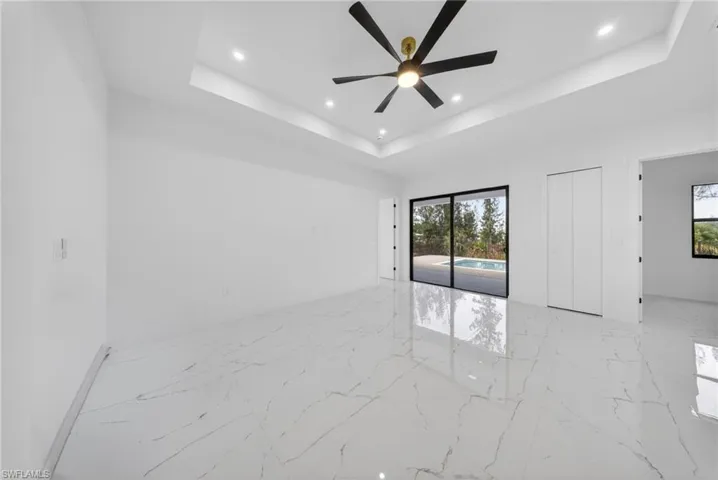 Spacious interior with high ceilings, recessed lighting, and a modern ceiling fan