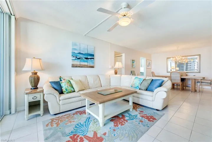 Living room featuring hanging lights, a ceiling fan, and light tile patterned flooring