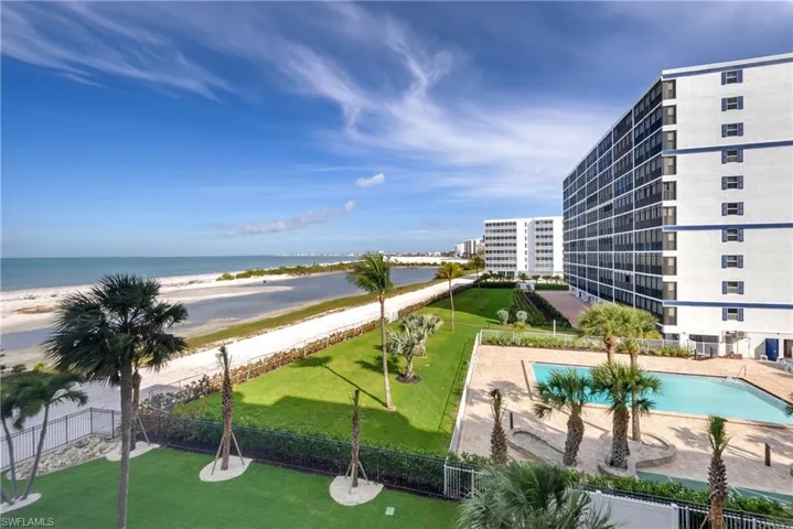 View of swimming pool with view of water and beach