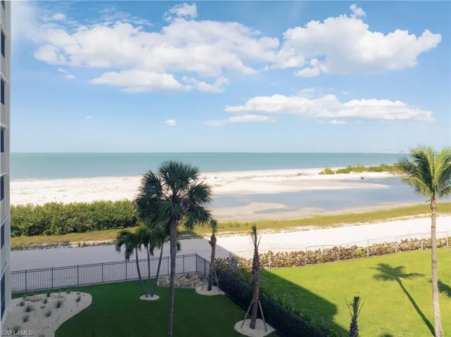 Water view featuring nearby beach and a fenced backyard
