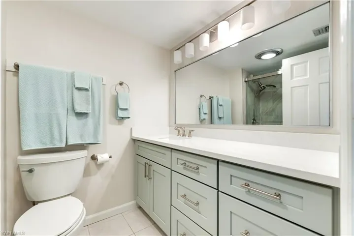 Bathroom featuring a stall shower, vanity, and light tile patterned floors