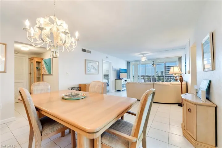 Dining area with light tile patterned floors, suspended lighting, and a ceiling fan