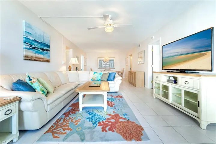 Living area featuring ceiling fan and light tile patterned floors