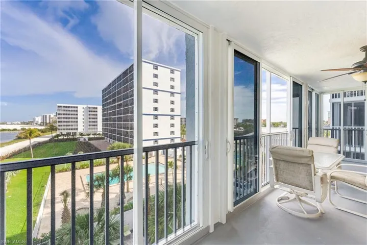 Balcony featuring ceiling fan and view of pool area