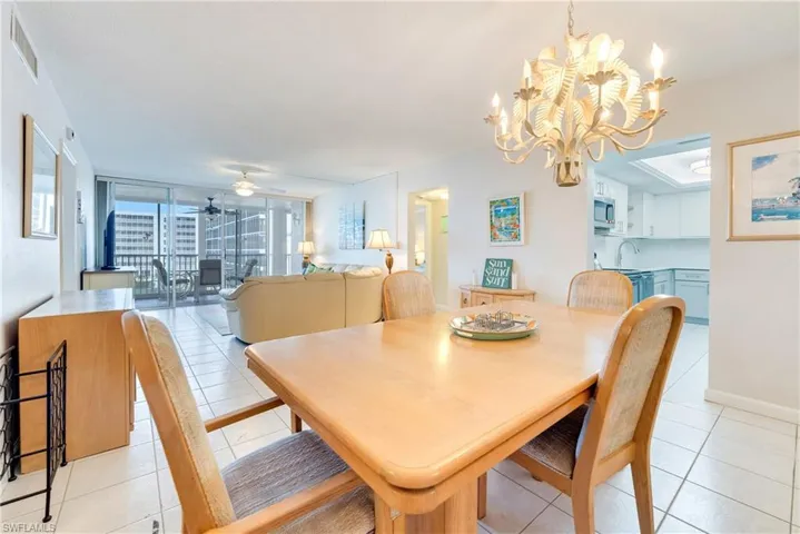 Dining space with expansive windows, light tile patterned floors, a ceiling fan, and hanging lights