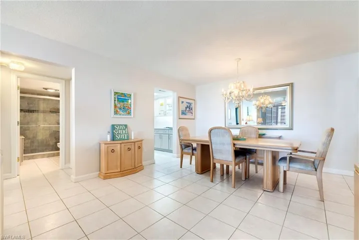 Dining space with hanging lights, light tile patterned flooring, and a textured ceiling