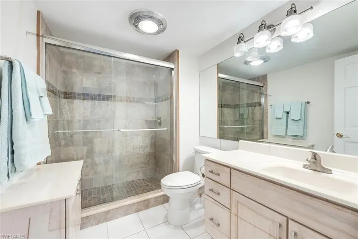 Bathroom with vanity, a stall shower, and light tile patterned floors