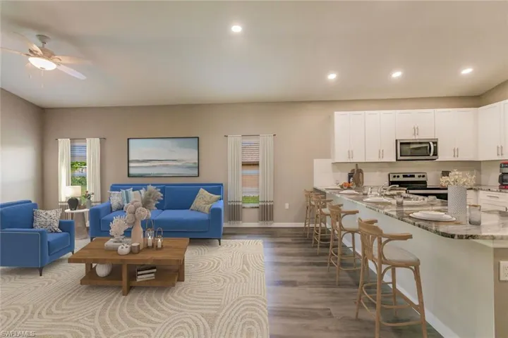 Living room with dark wood finished floors, a ceiling fan, and recessed lighting