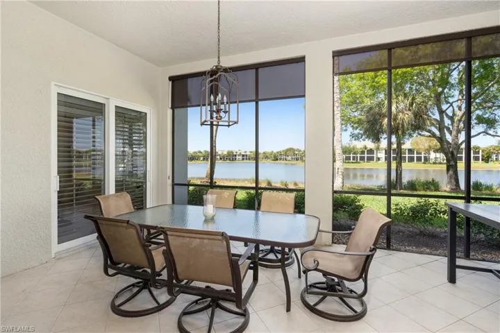 Sunroom / solarium with a chandelier, a water view, and healthy amount of natural light