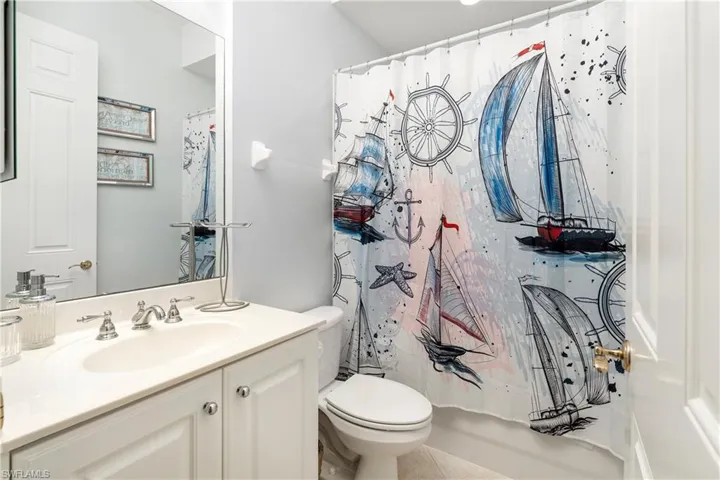 Full bath featuring vanity, tile patterned flooring, and shower / bath combo with shower curtain