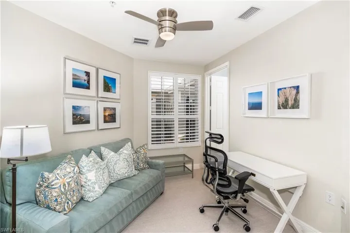 Carpeted home office featuring baseboards and ceiling fan