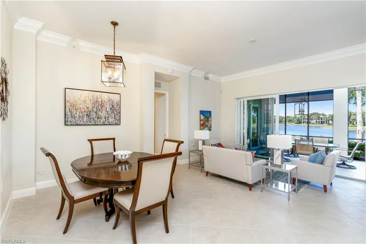 Dining space featuring a chandelier, ornamental molding, a water view, and light tile patterned floors