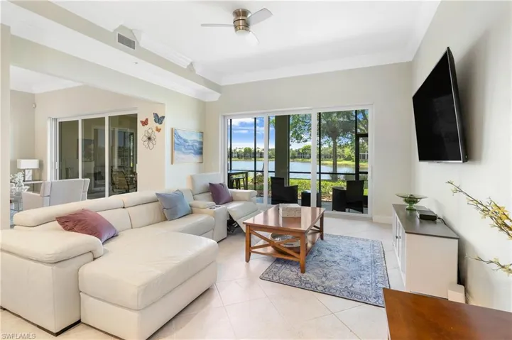 Living area featuring ornamental molding, light tile patterned flooring, and ceiling fan