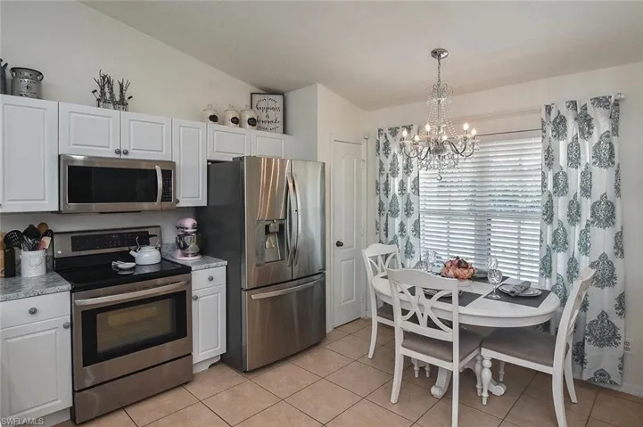 The spacious eat-in kitchen has white raised-panel cabinetry and stainless appliances.
