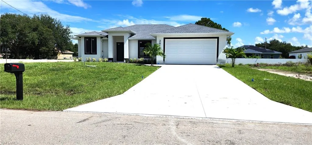 View of front of property featuring a garage and a front yard
