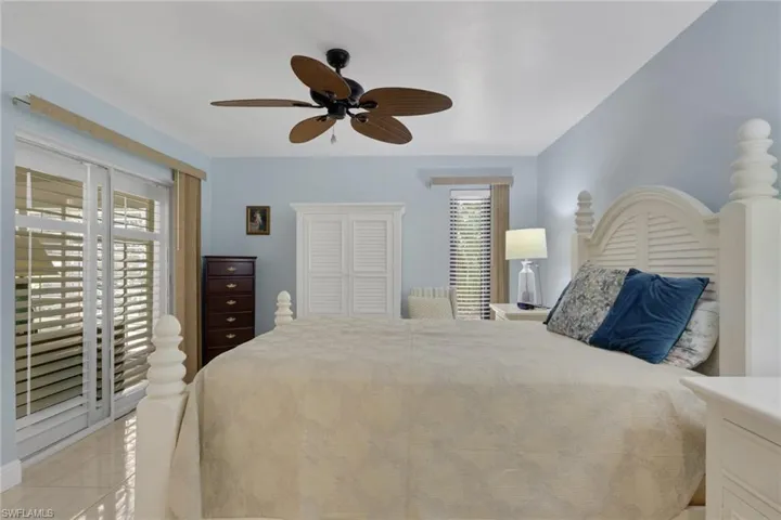 Bedroom featuring access to outside, light tile patterned floors, and ceiling fan