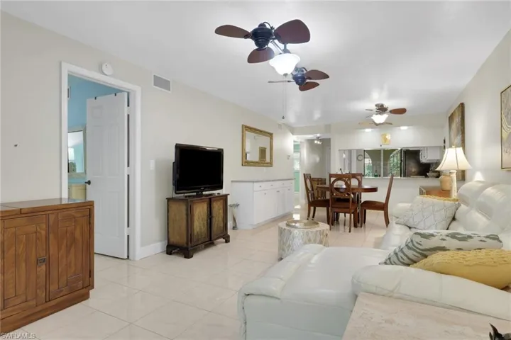 Living area featuring a ceiling fan and light tile patterned floors