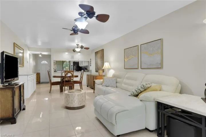 Living area featuring ceiling fan and light tile patterned floors