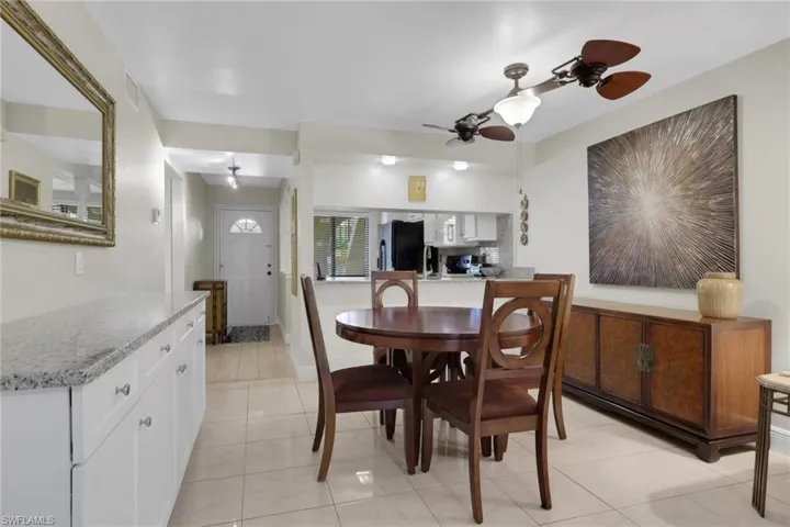 Dining area with ceiling fan and light tile patterned flooring
