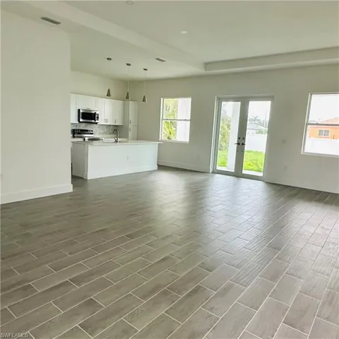 Unfurnished living room featuring wood finish floors and french doors