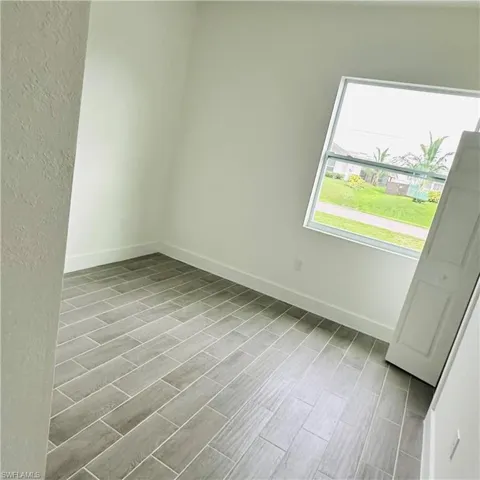 Unfurnished bedroom featuring wood finish floors and a textured wall