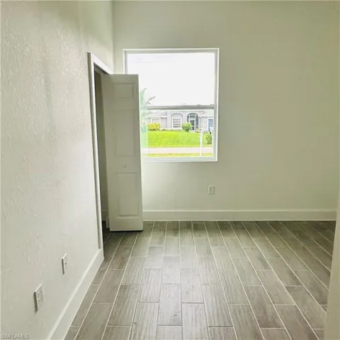 Empty room featuring a textured wall and wood finish floors