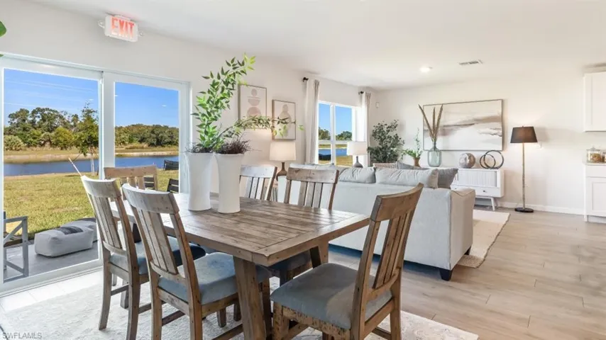 Model home. Dining room featuring light wood finished floors and a water view